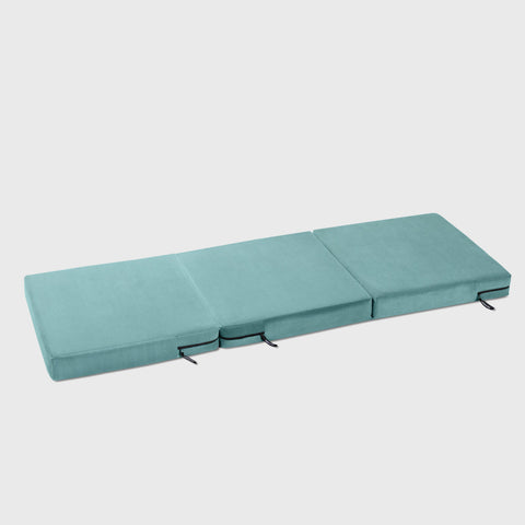 Teal folding mattress on a white background