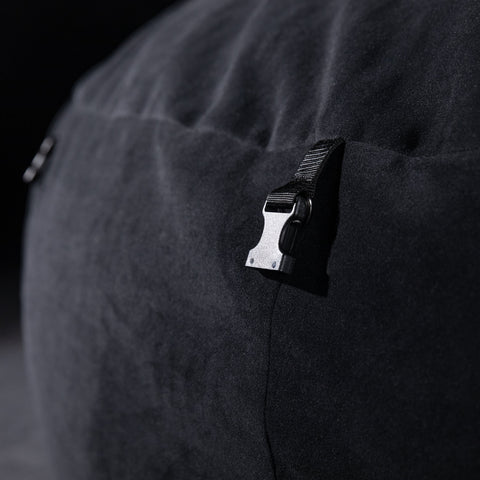 Close-up of a black clip on a dark fabric surface