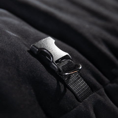 Close-up of a black strap with a plastic buckle on a dark fabric background